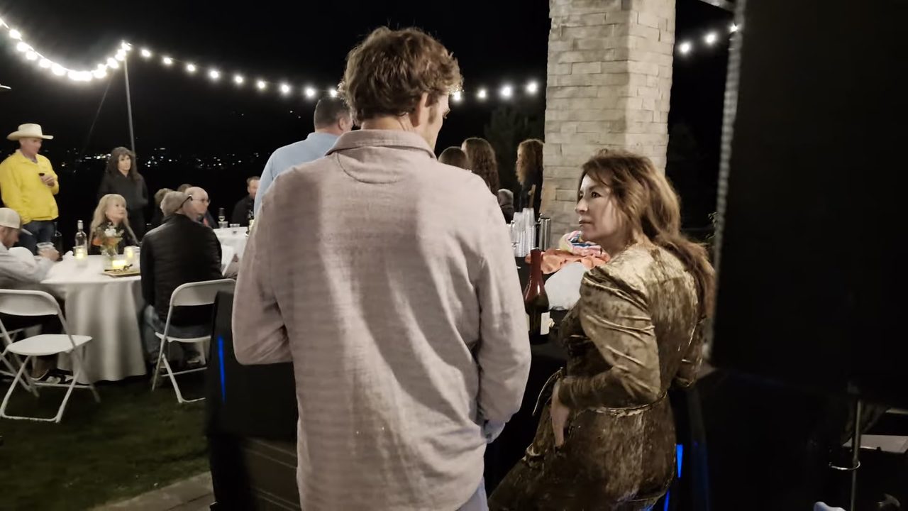 Guests at the round tables under the string lights after dark