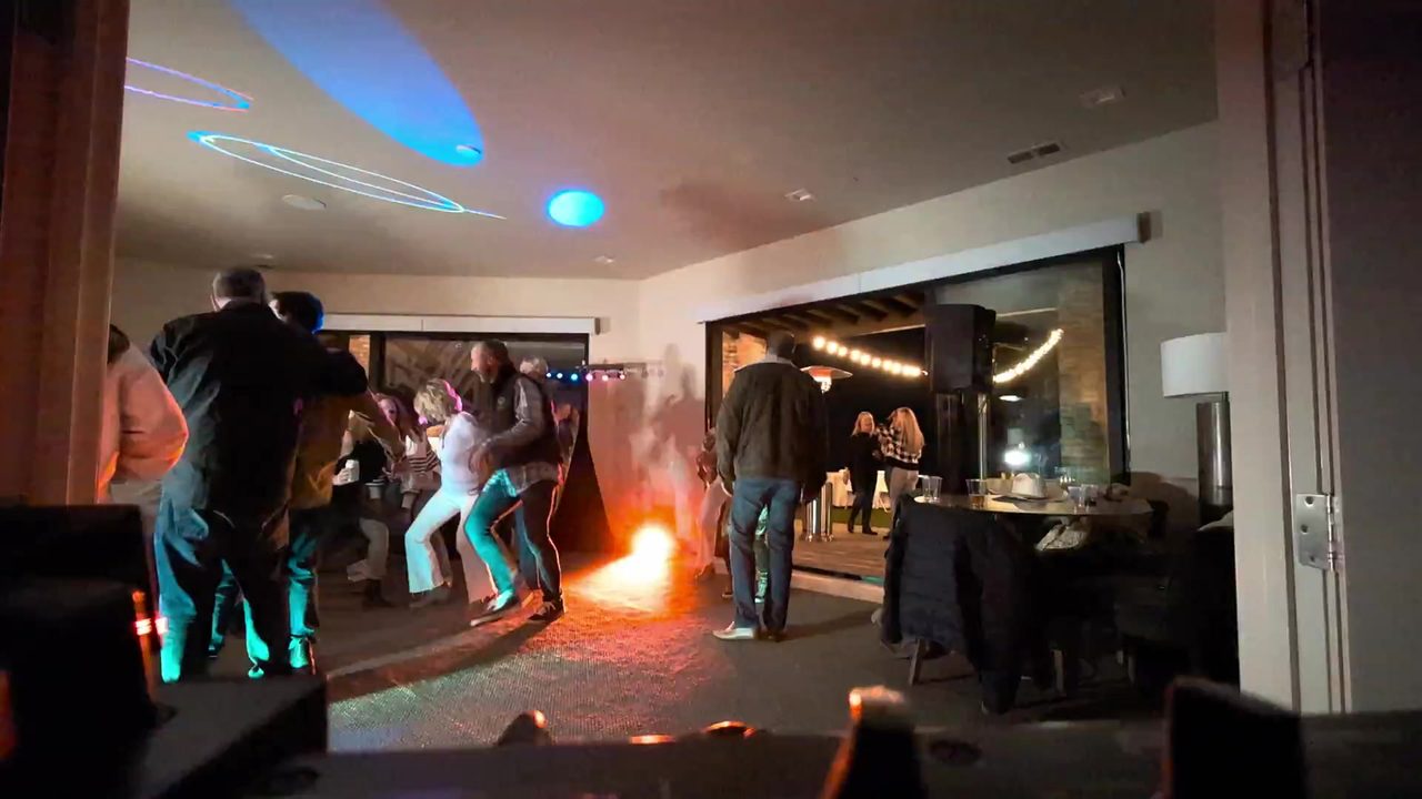 Guests dancing in the fog and colored lights