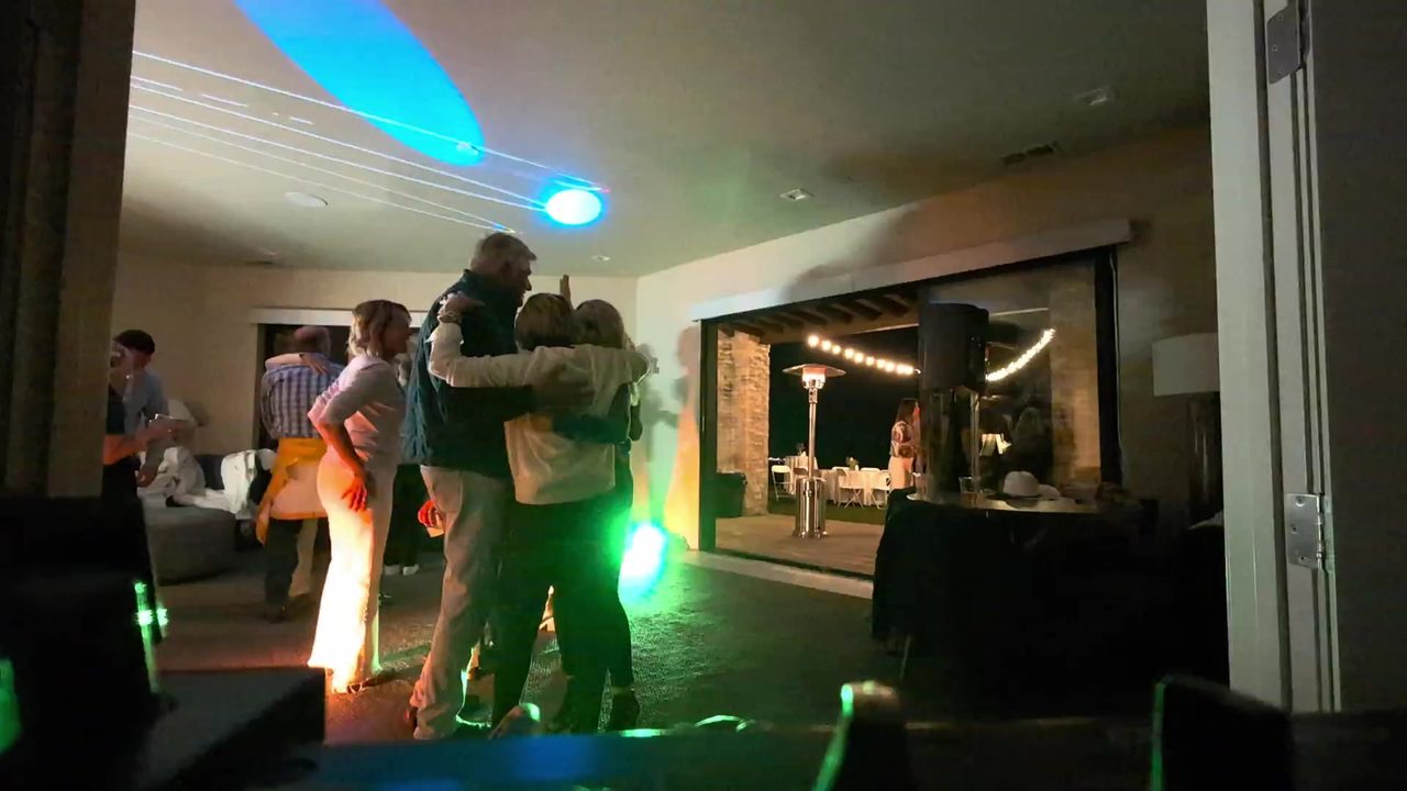 Friends dancing together in the green and orange lights