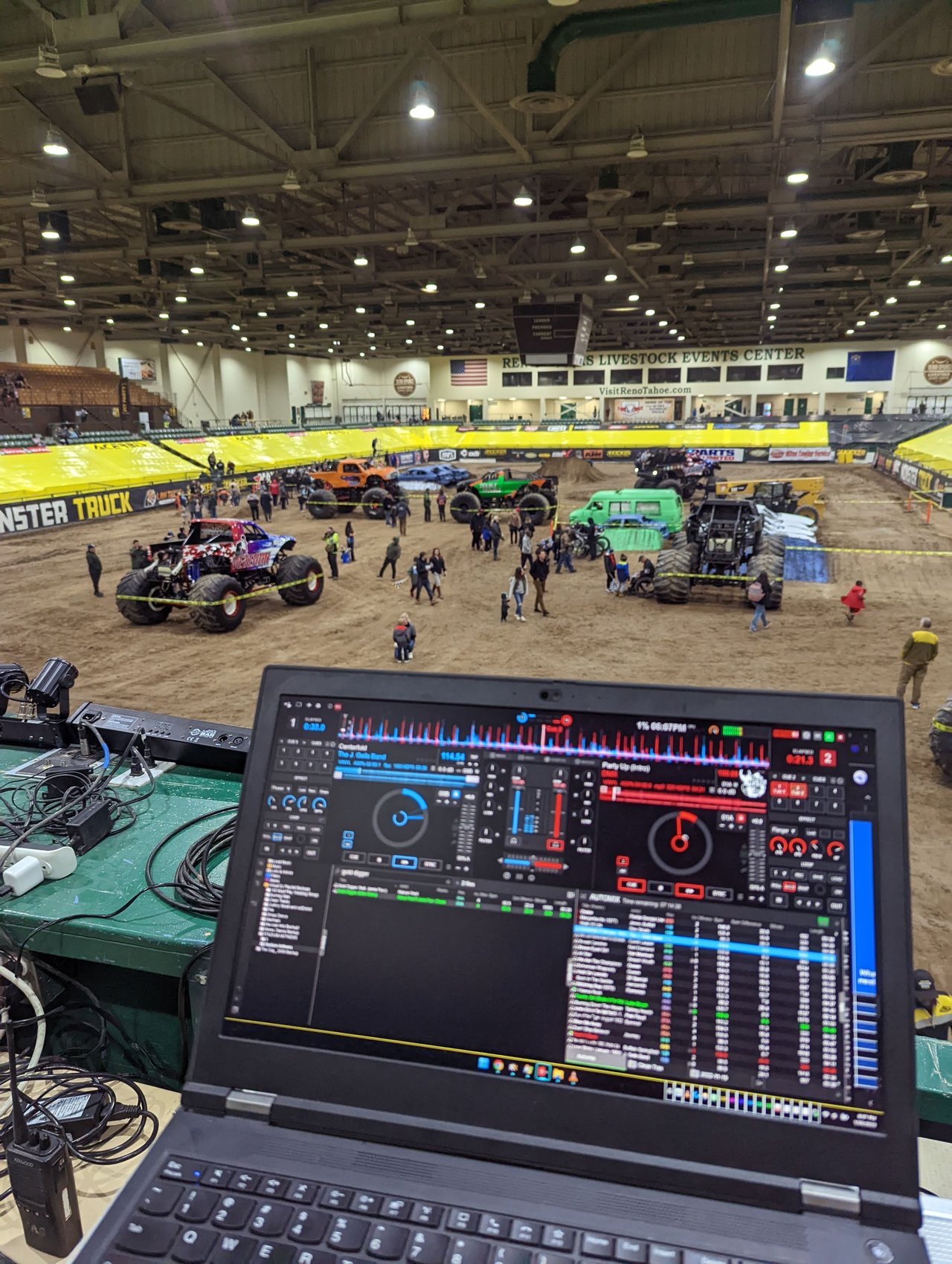 The laptop at the DJ rail while fans walk the track
