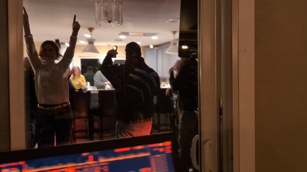 A guest with both arms up dancing by the kitchen during the party