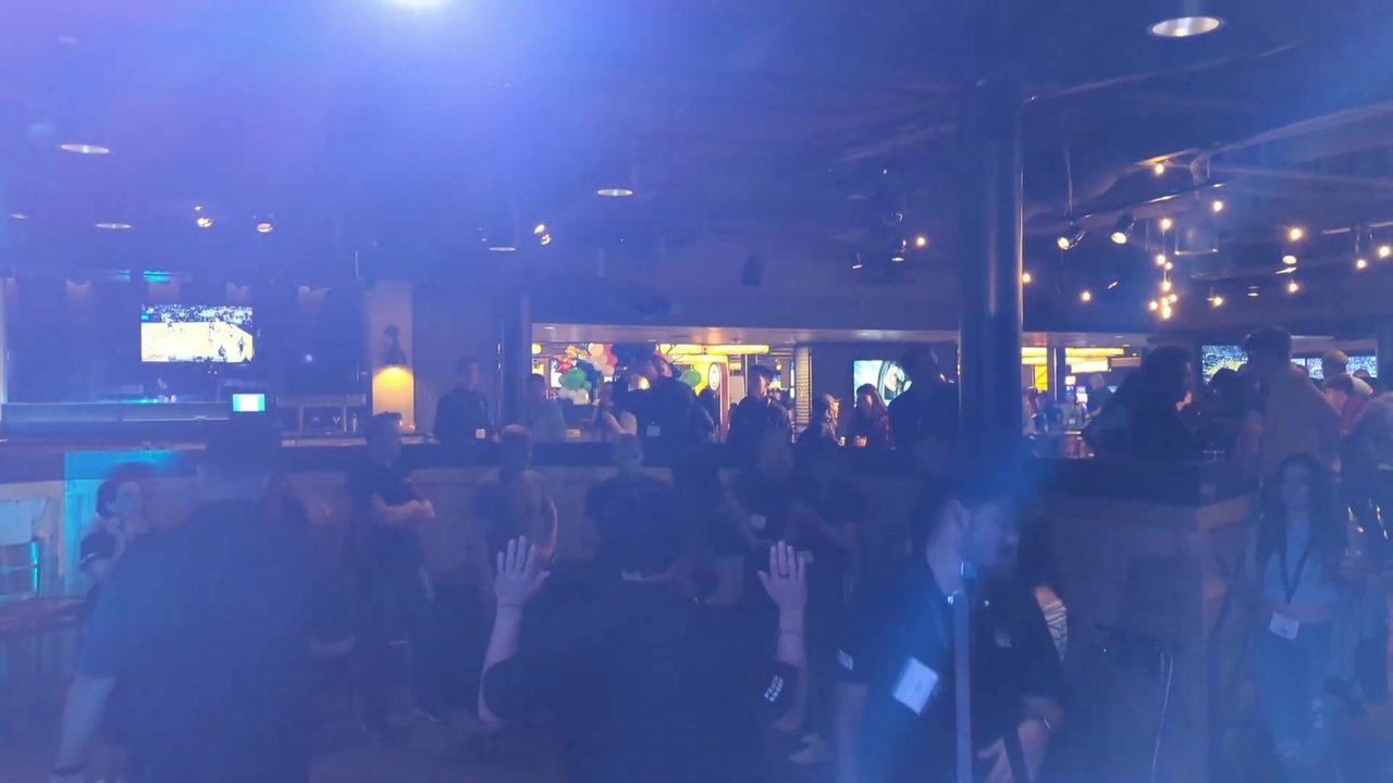Guests with their hands up by the bar at the PENTA mixer