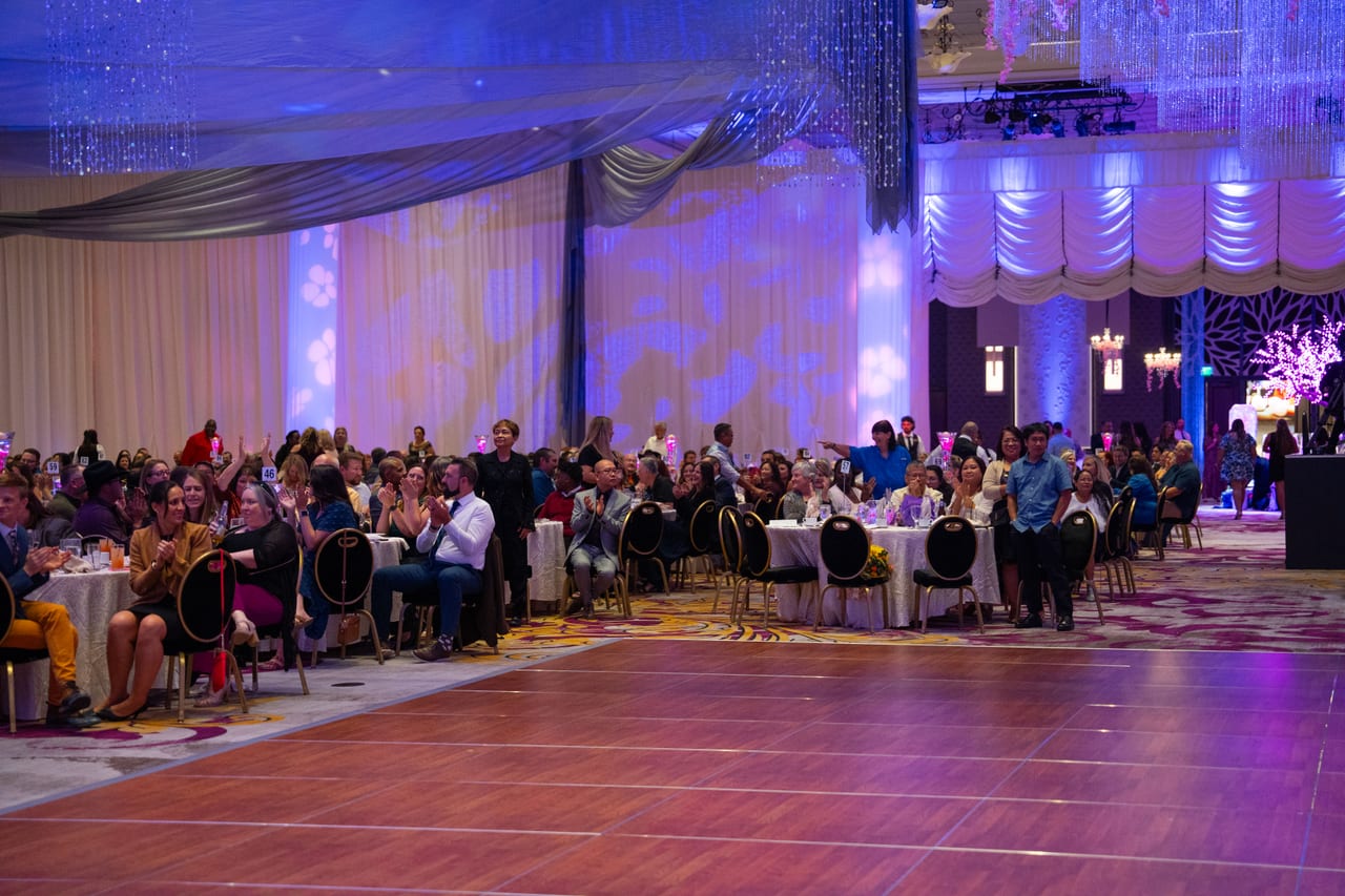 The whole ballroom applauding, seen from the empty dance floor