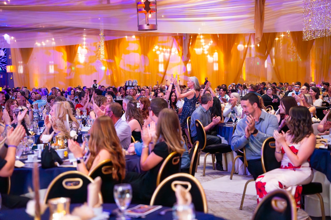 A ballroom full of Renown guests clapping along at their tables