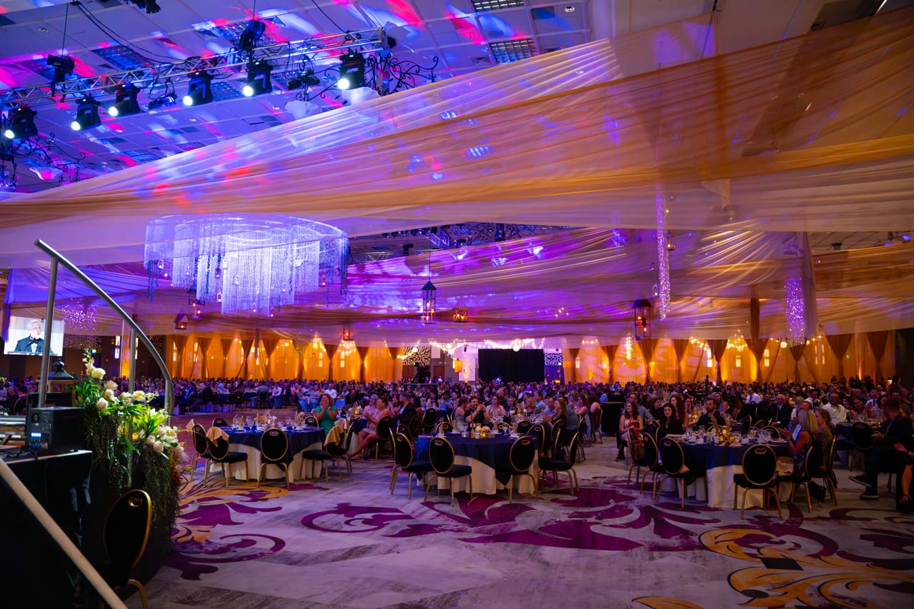 The full Tuscany Ballroom seen from the stage steps under moving lights