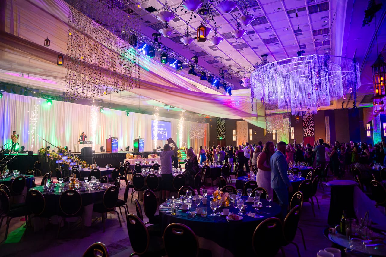 The Tuscany Ballroom lit purple and green with the stage glowing at the far end