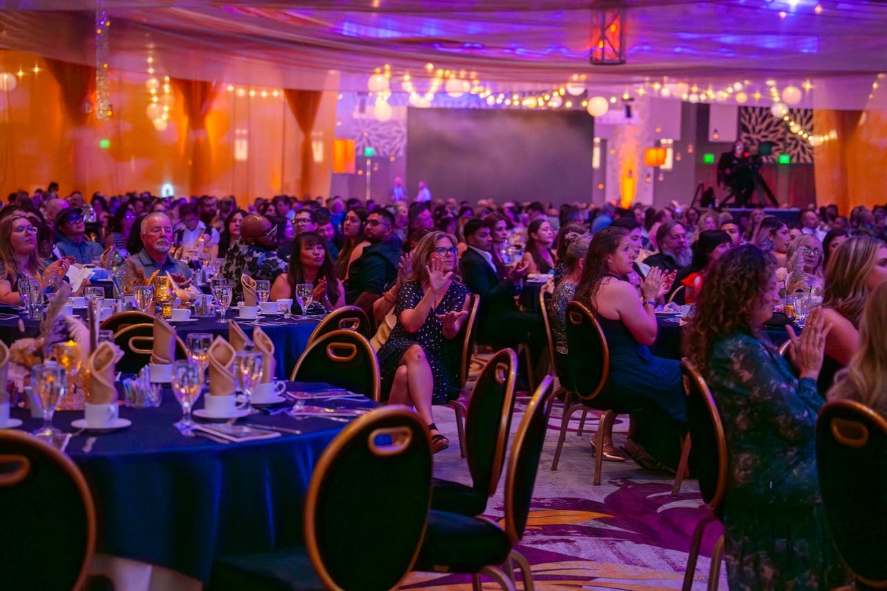 A packed ballroom of Renown guests applauding from their tables