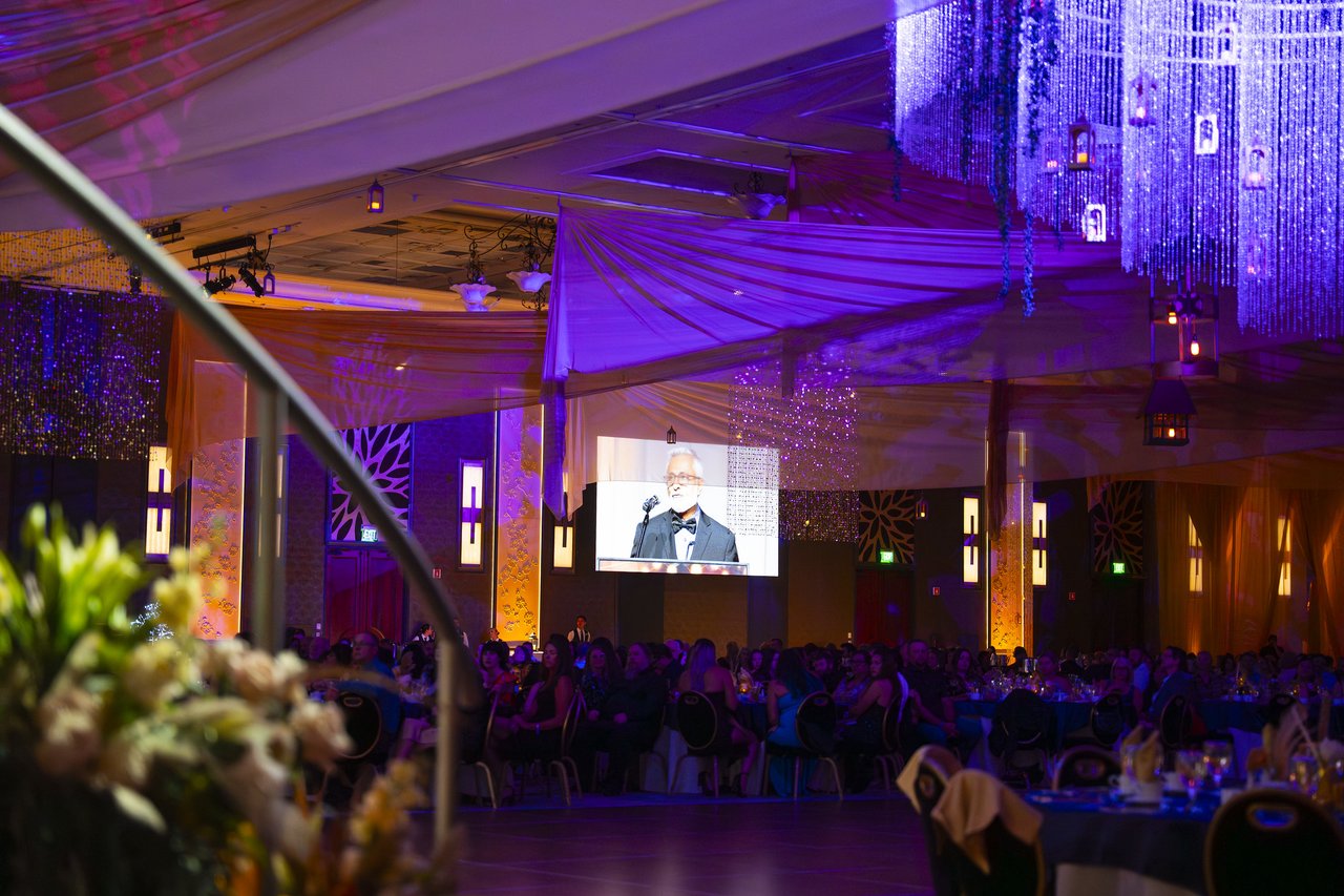 The ballroom under purple light and crystal chandeliers during the speeches
