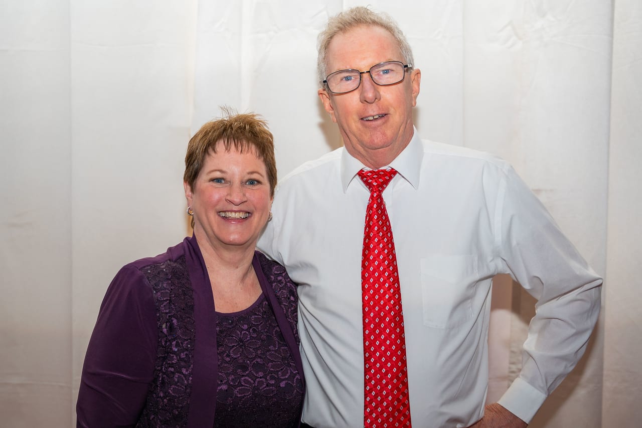 A Renown couple smiling together in front of a white backdrop