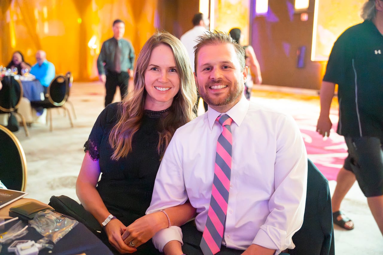 A Renown couple smiling together at their table before dinner