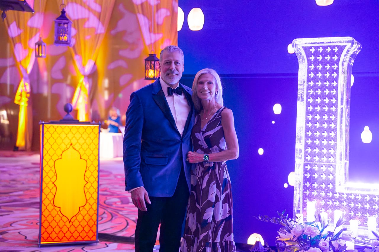 A Renown couple posing beside the glowing LOVE letters