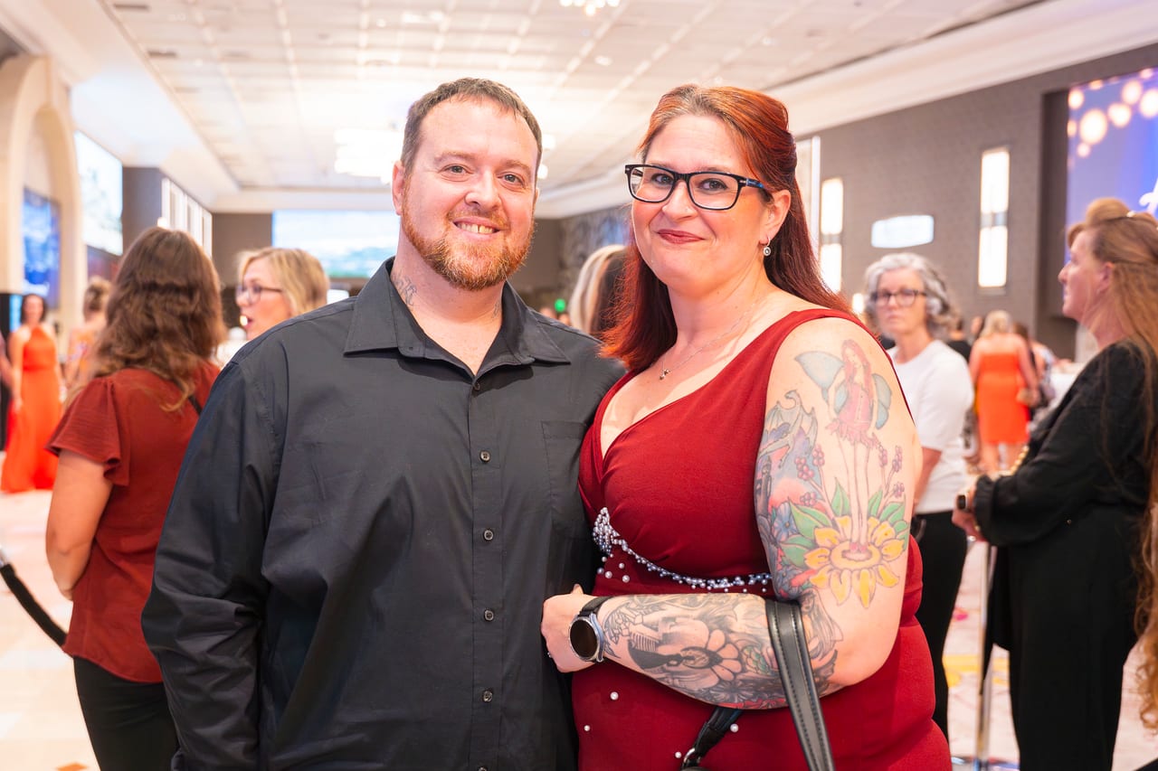 A Renown couple smiling in the lobby as guests arrive