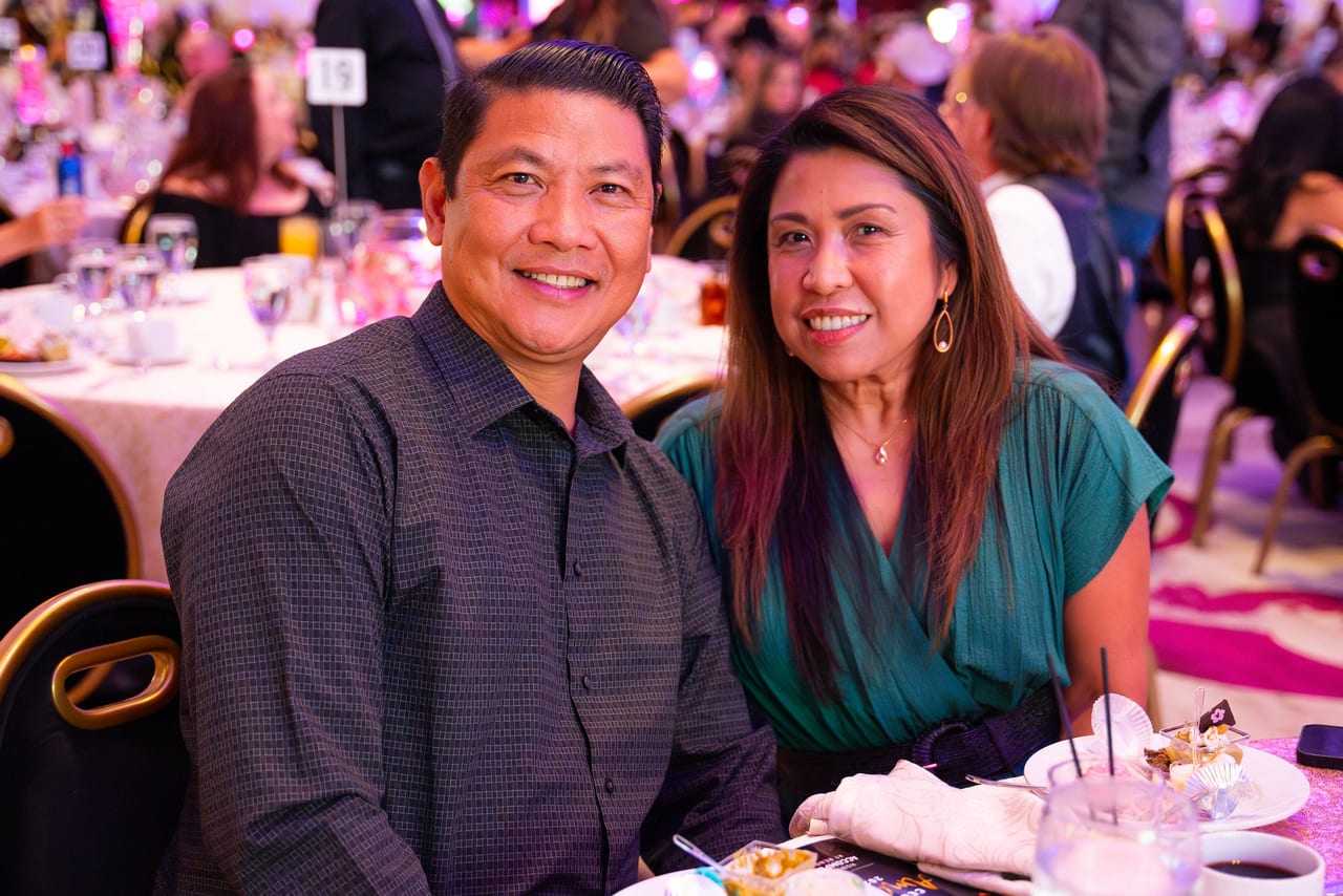 A Renown couple smiling at their table during dinner