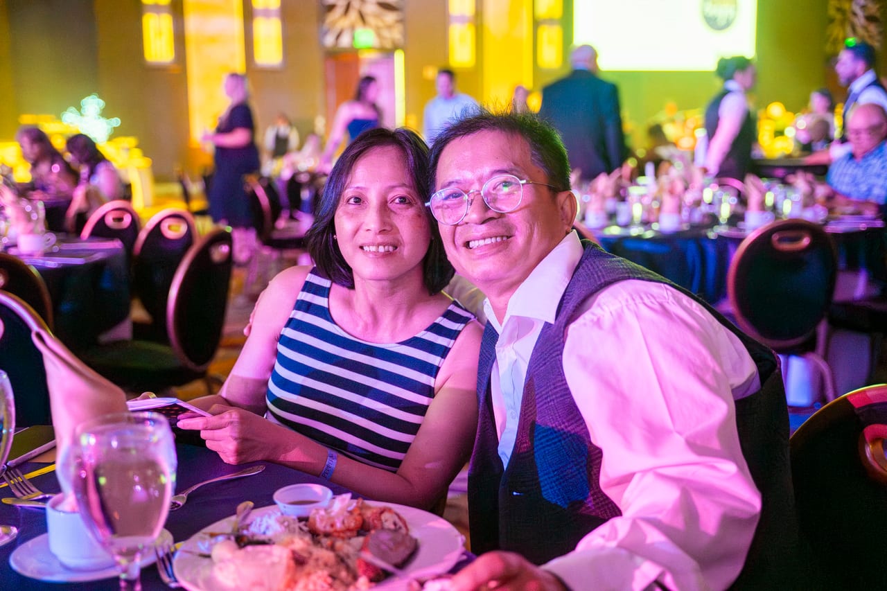A Renown couple leaning in for a photo during dinner