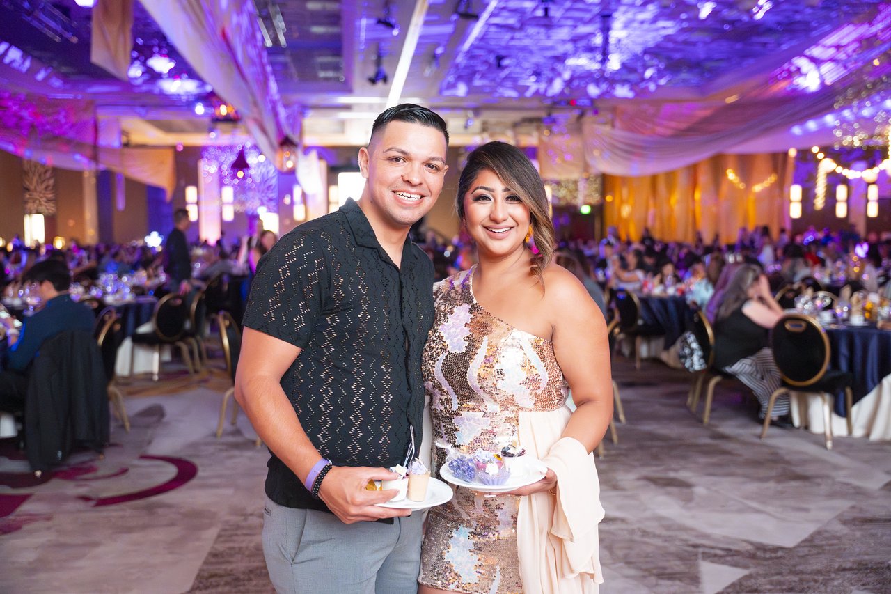 A Renown couple smiling with their dessert plates