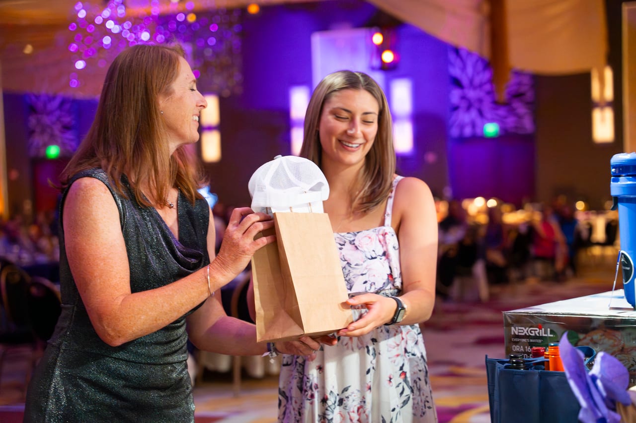 A Renown coworker smiling as she hands a gift bag to a teammate