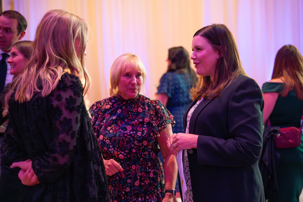 Three Renown coworkers catching up by the drapes