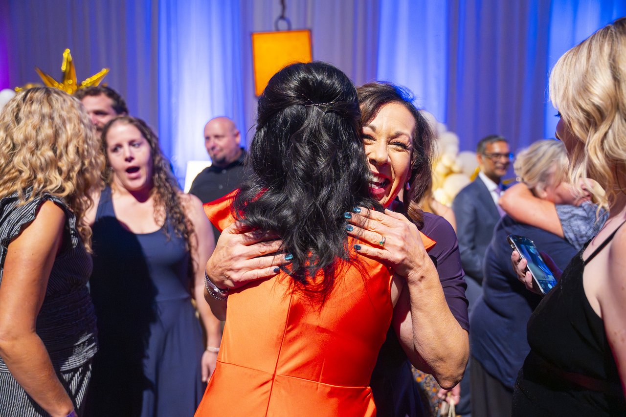 Two Renown coworkers hugging in the crowd