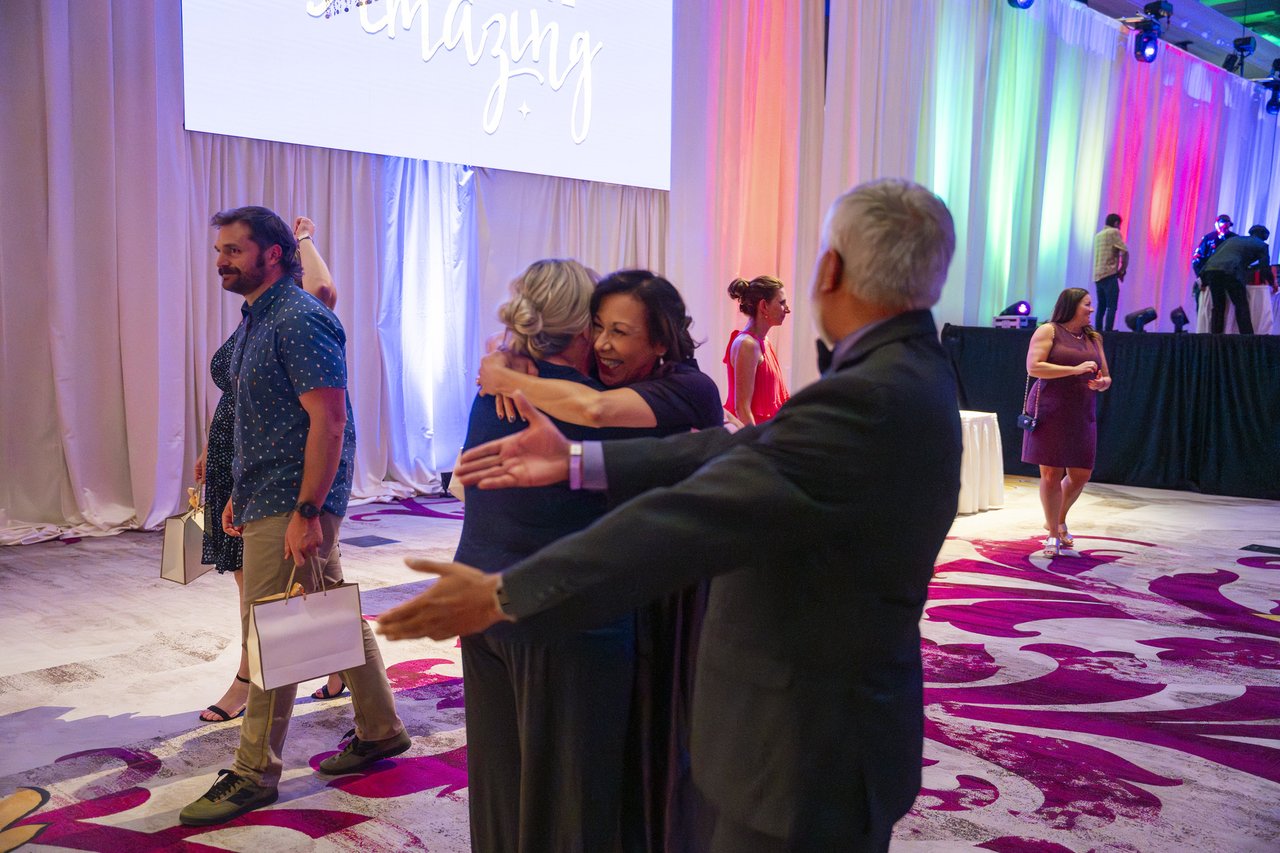 Renown coworkers hugging on the dance floor