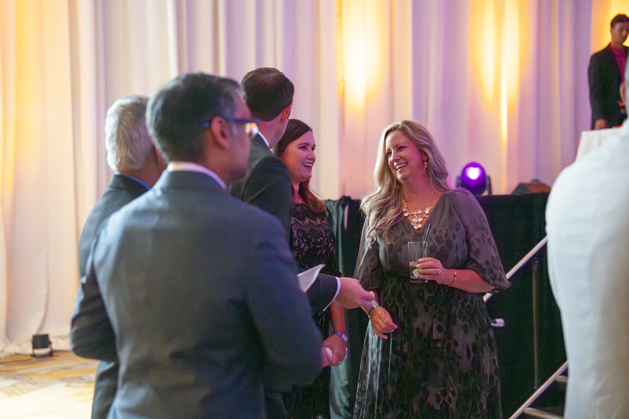 Renown coworkers mingling by the stage
