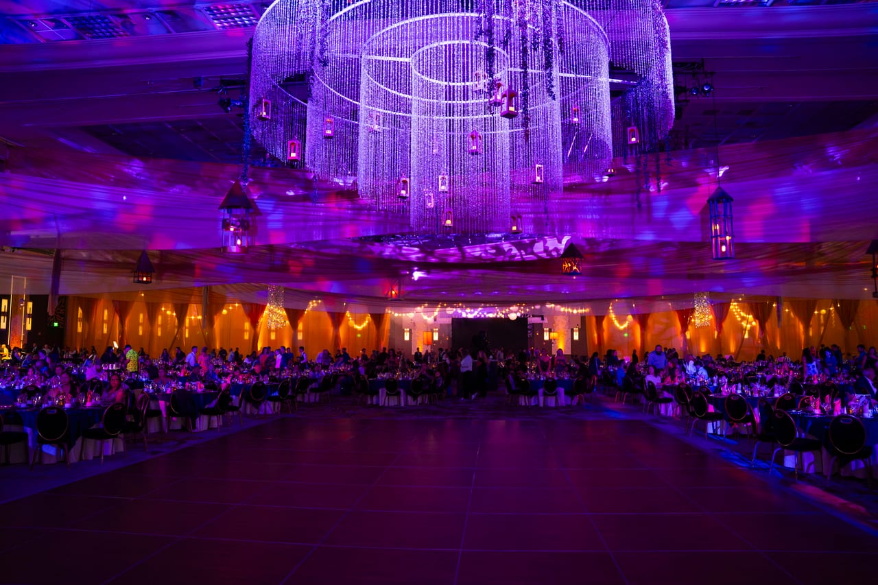 The giant crystal chandelier glowing purple over the open dance floor