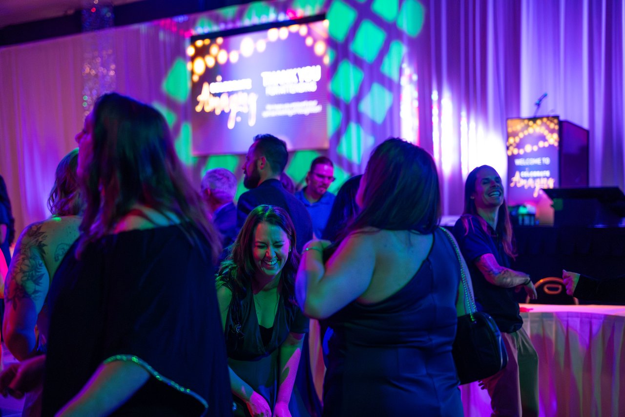 Renown guests dancing in front of the stage and the big screen