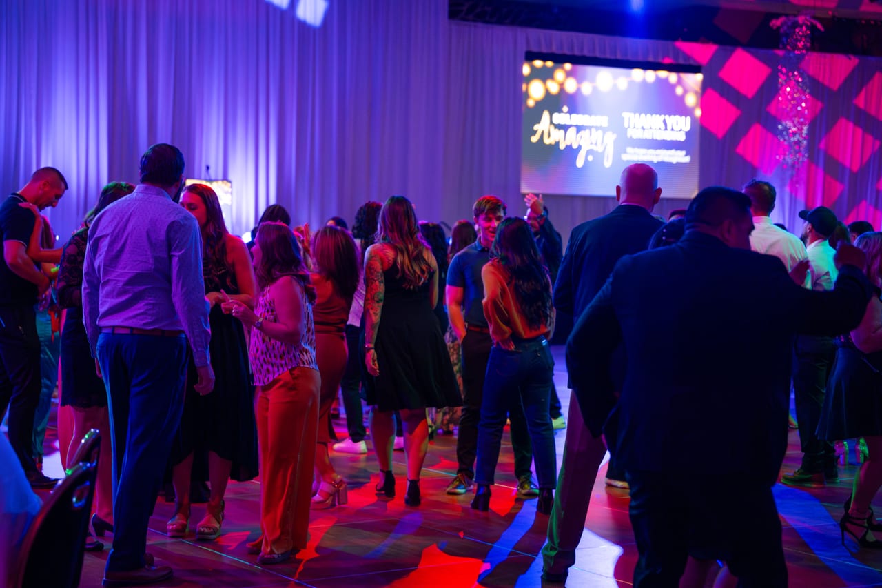Renown guests dancing in front of the Celebrate Amazing thank you screen