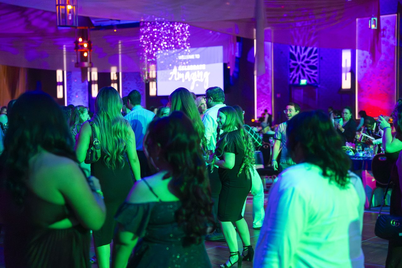 The Renown crowd on the dance floor under purple and green lights