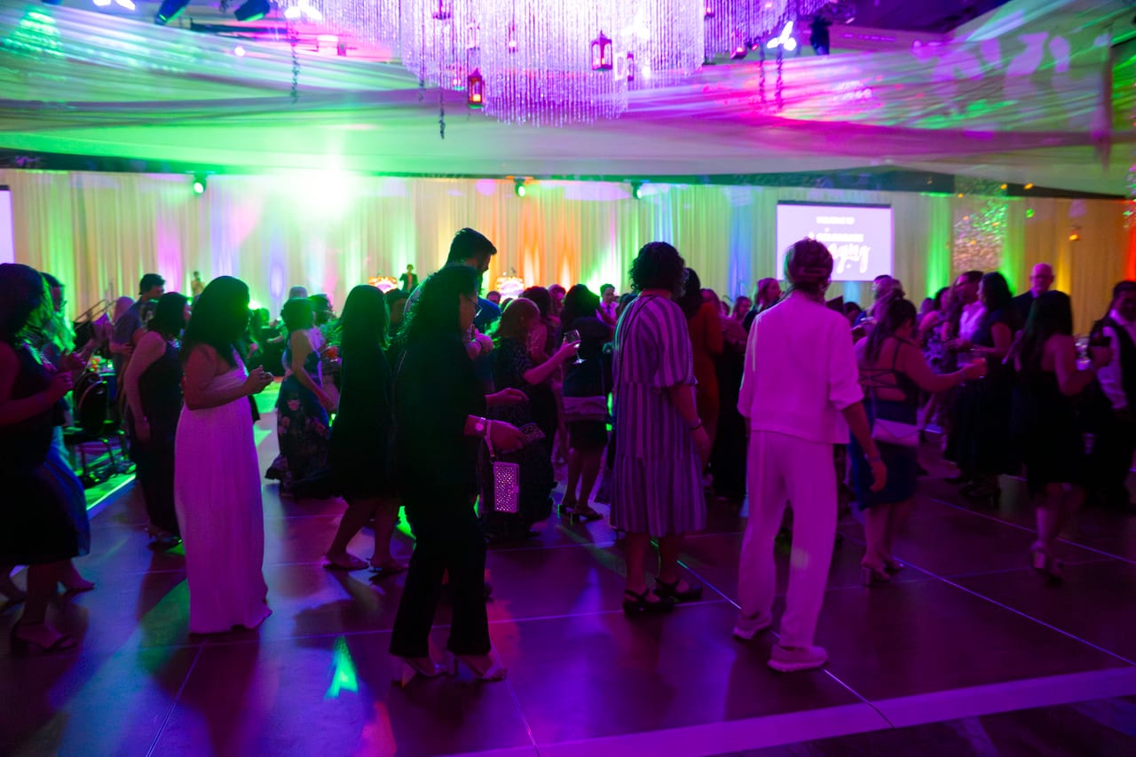 Renown guests dancing under green and purple lights