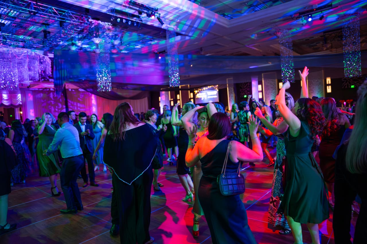 Renown guests dancing under swirling disco lights in the ballroom