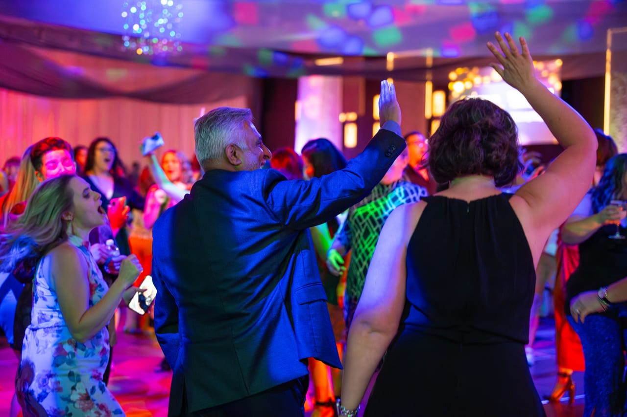 Renown guests dancing with their hands up under the party lights