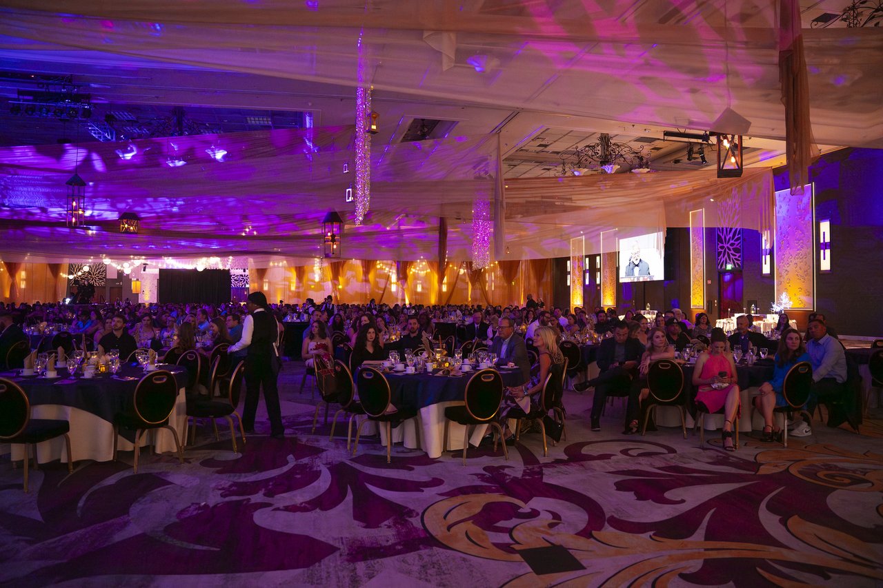 The dark ballroom seen from the back during the speeches