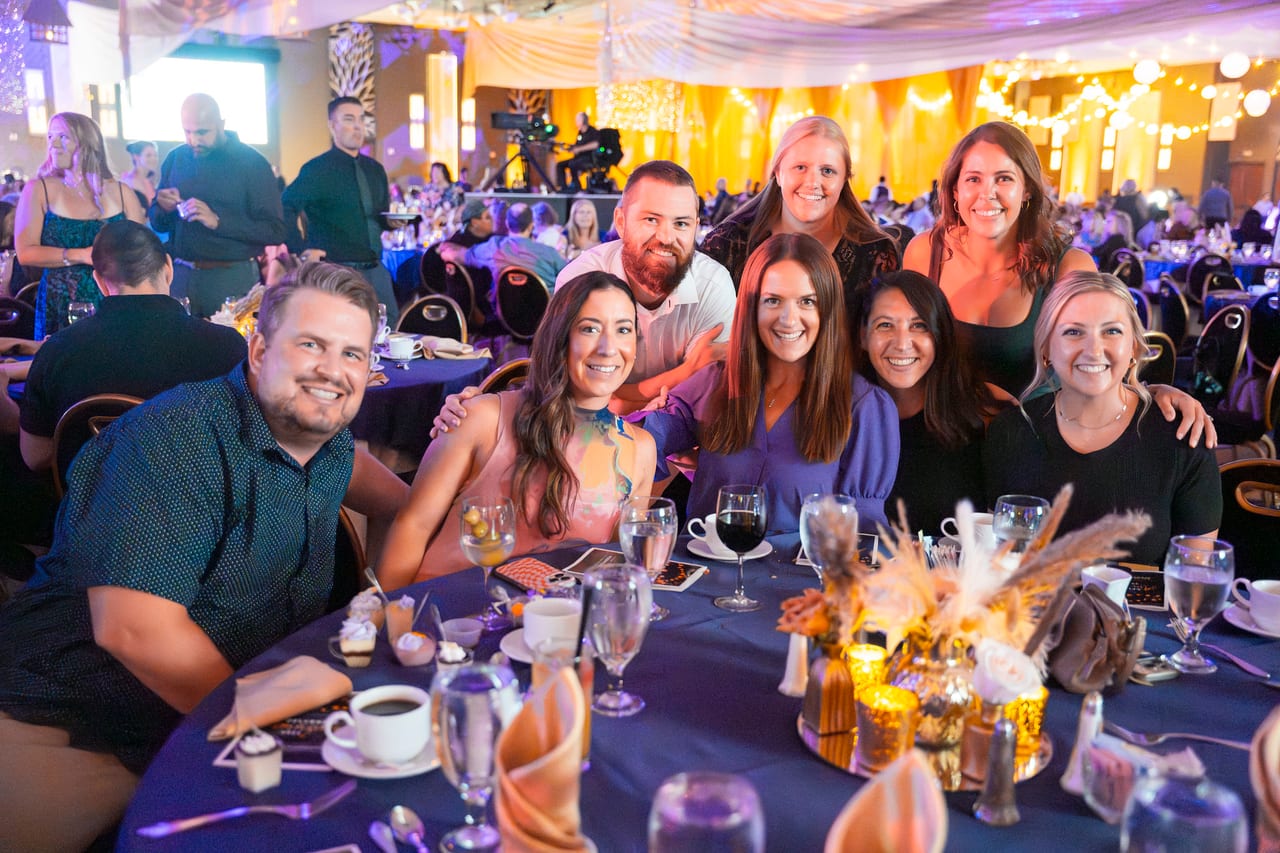 Eight Renown coworkers gathered around their candlelit table
