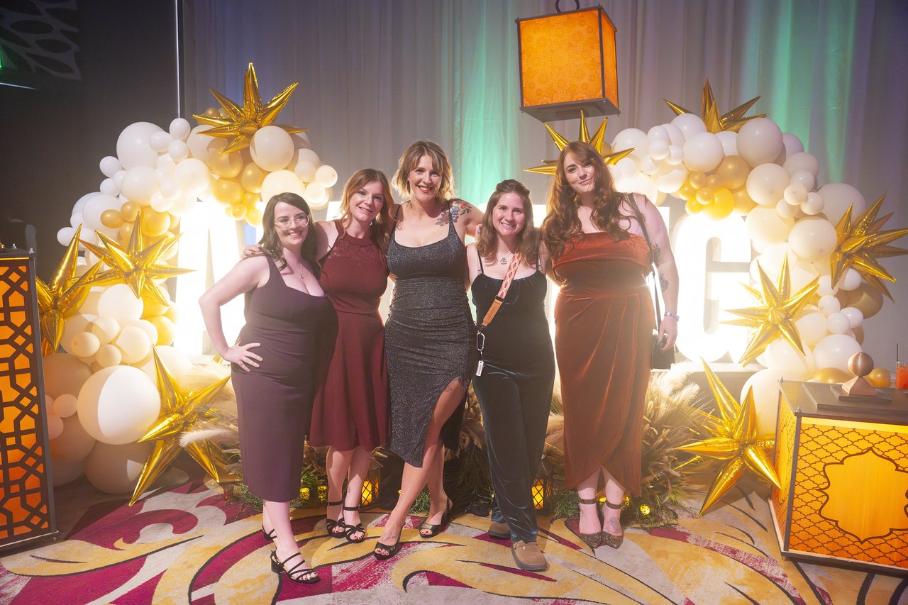 Five Renown friends posing at the gold balloon arch