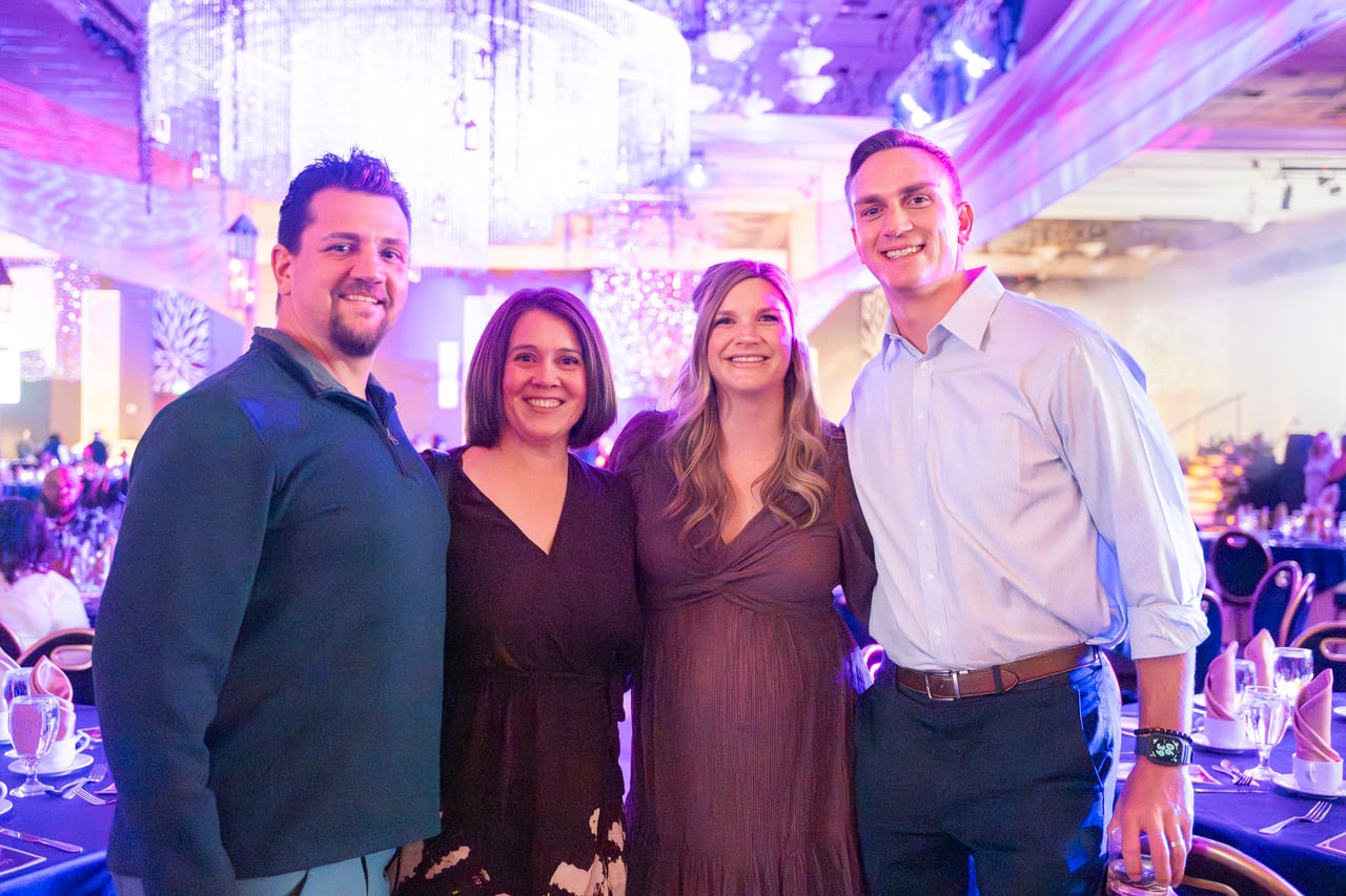 Four Renown coworkers posing together in the ballroom