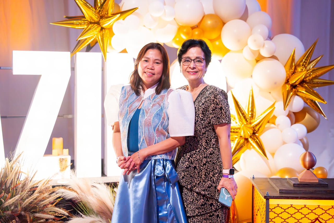 Two Renown friends posing at the balloon arch with gold stars