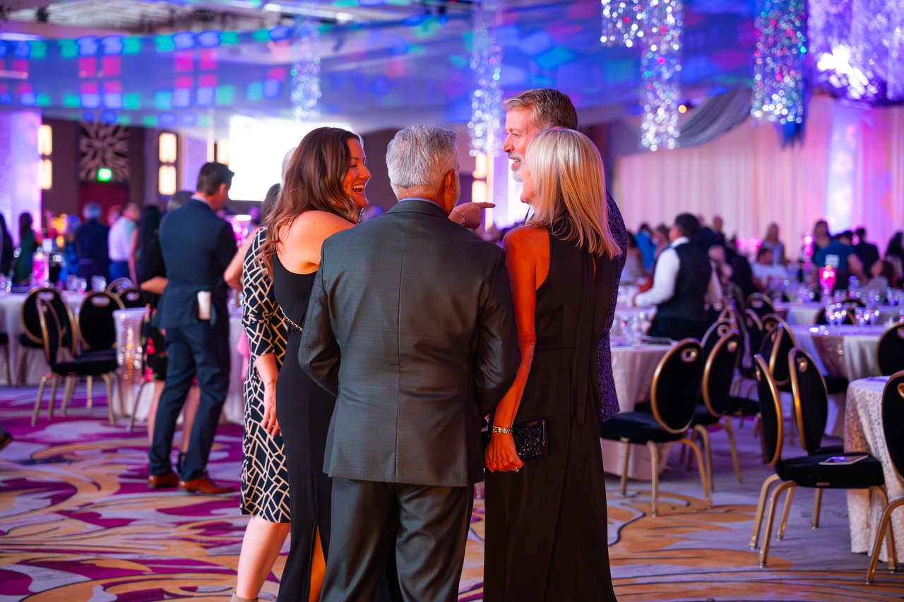 Renown friends talking together under the ballroom lights