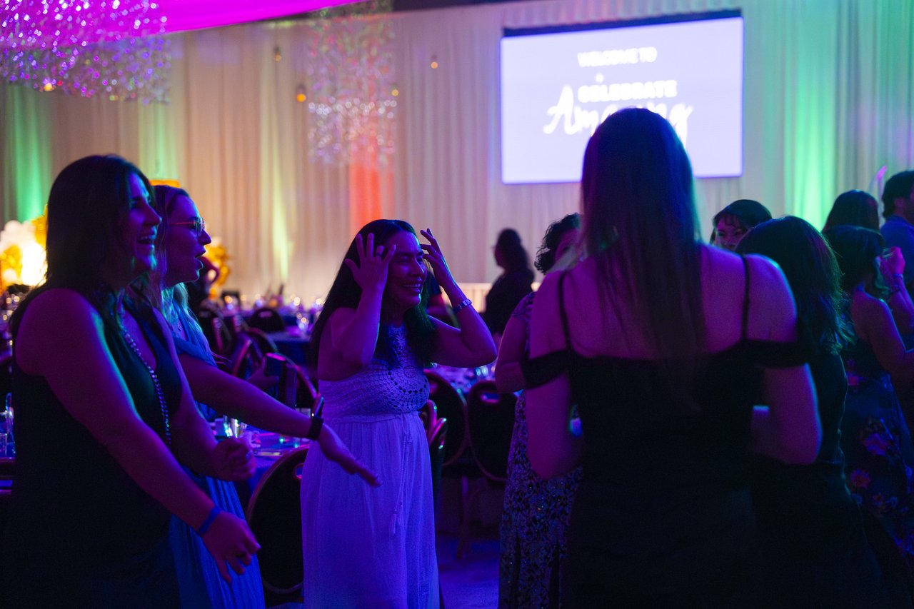 Renown friends dancing beneath the Celebrate Amazing screen