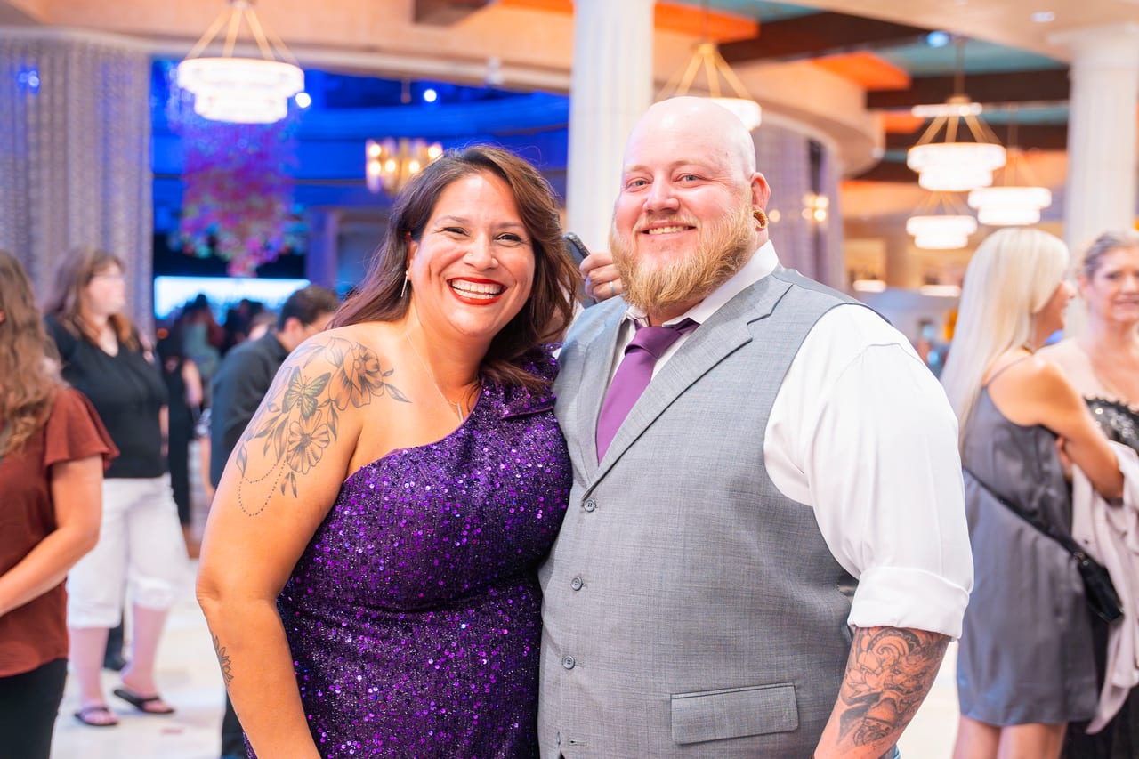 Two Renown friends smiling in the lobby, one in purple sequins