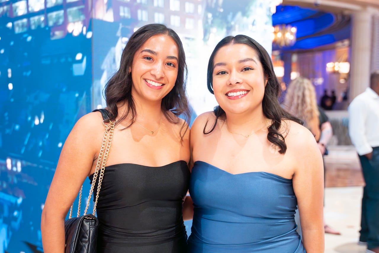 Two Renown friends smiling in the blue glow of the Peppermill lobby