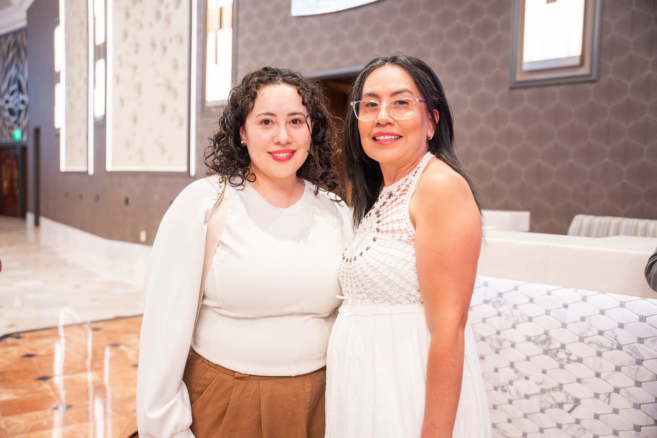 Two Renown friends smiling in the prefunction hall outside the ballroom