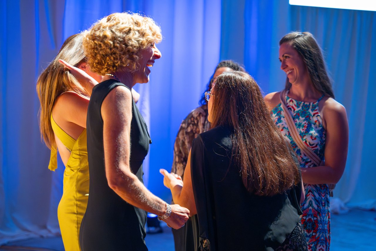 Renown friends laughing together by the blue drapes