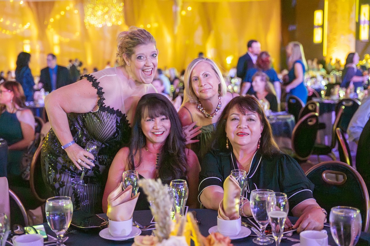 Renown friends smiling up from their dinner table