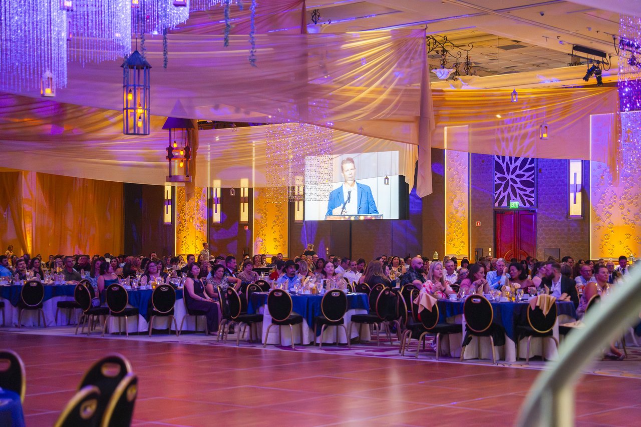 The full ballroom seen from the dance floor with the speaker on screen