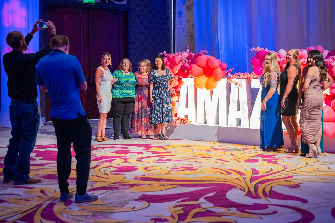 A group of Renown coworkers posing at the Amazing balloon wall while friends take photos