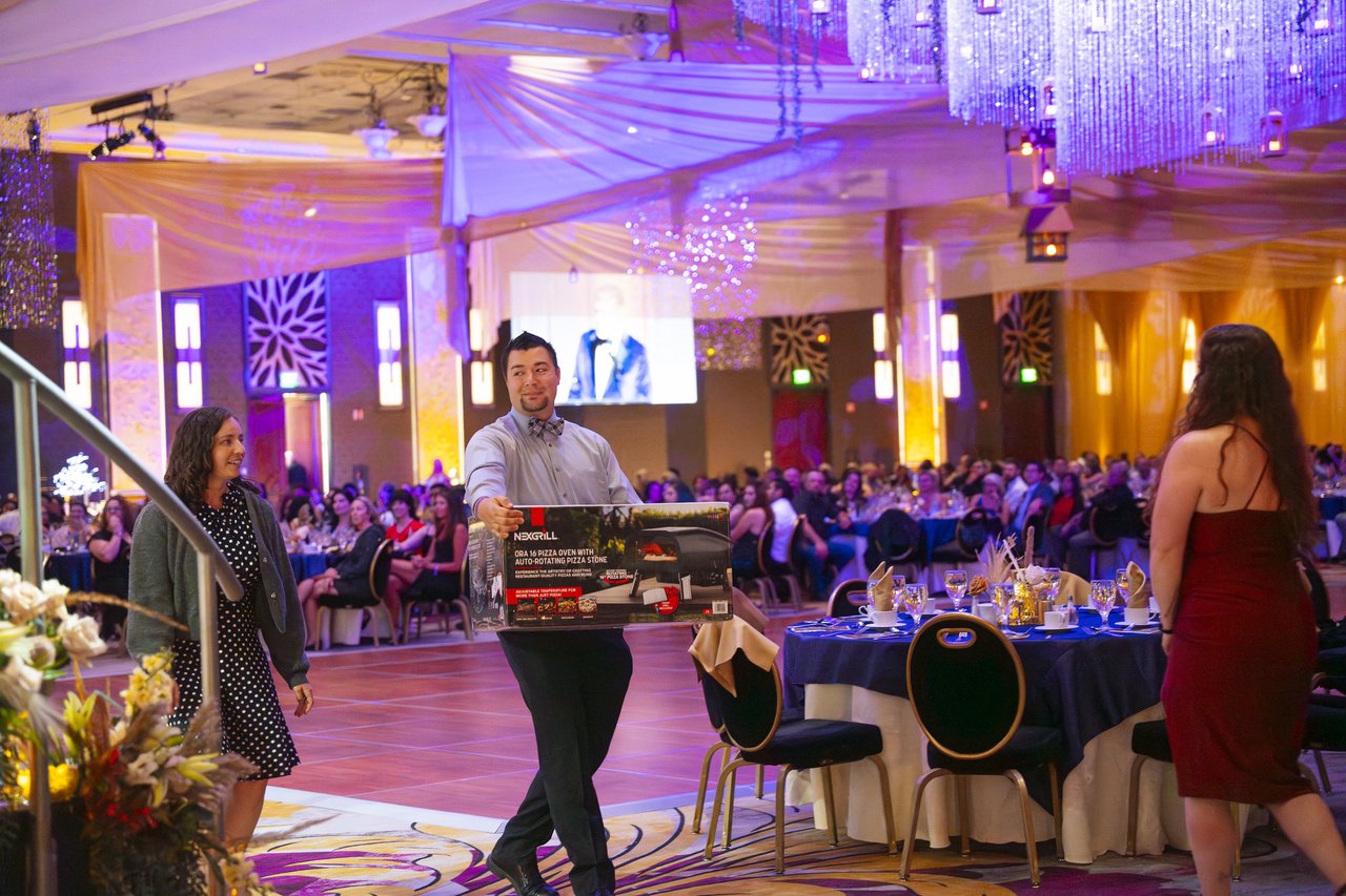 A Renown guest carrying a griddle prize past the tables