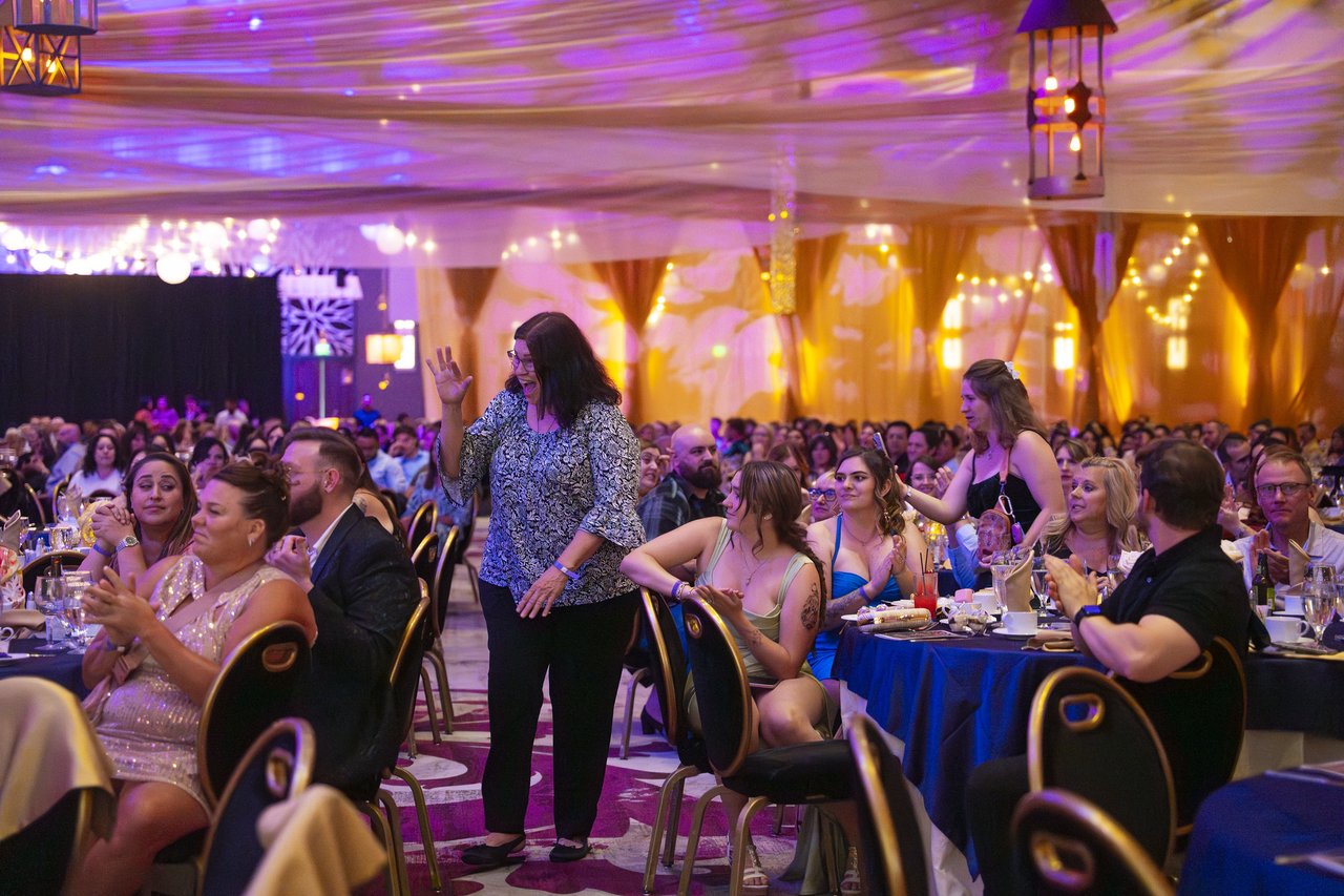 A Renown guest cheering from her table in the packed room