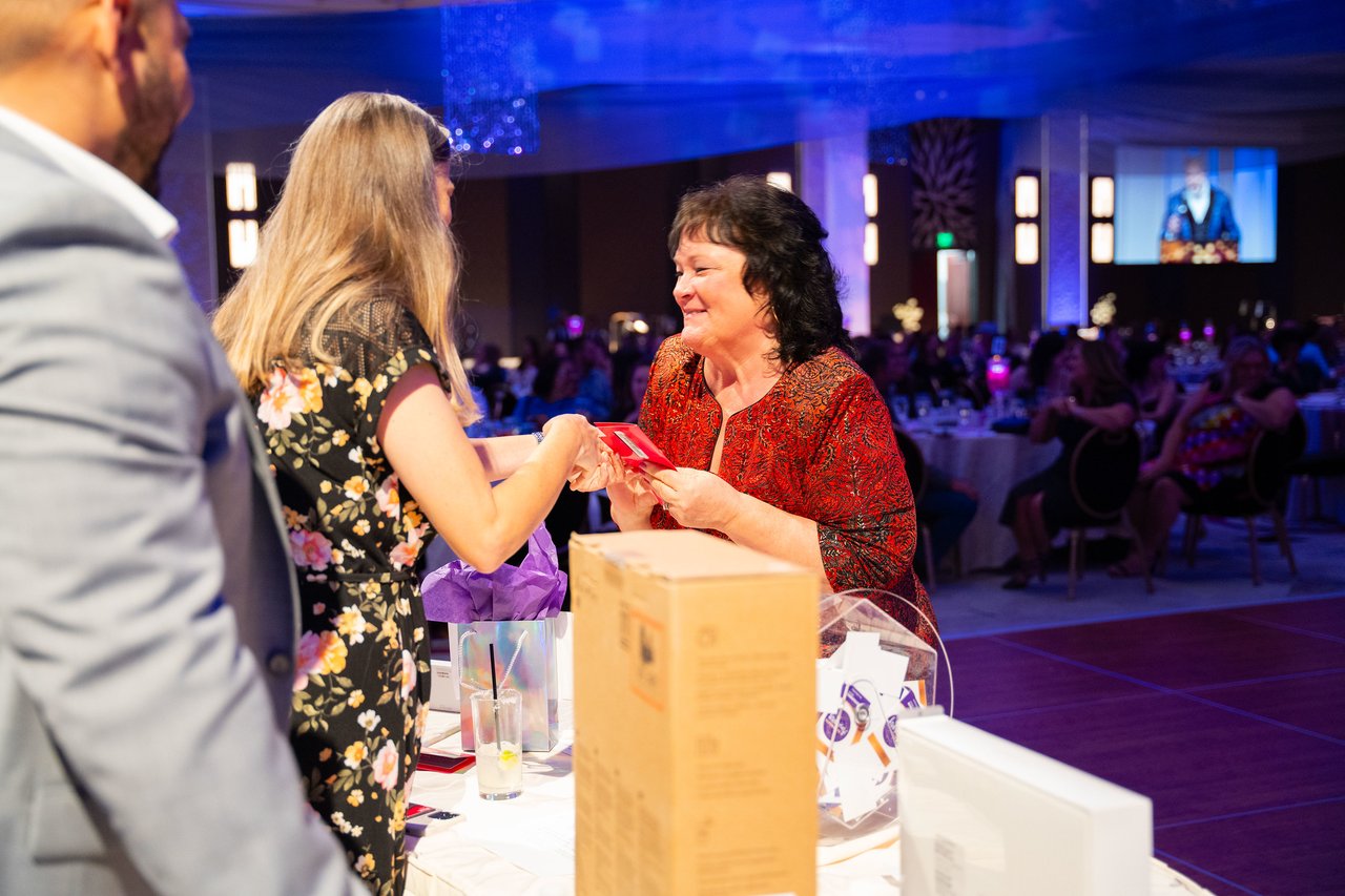A Renown guest collecting her raffle prize at the prize table
