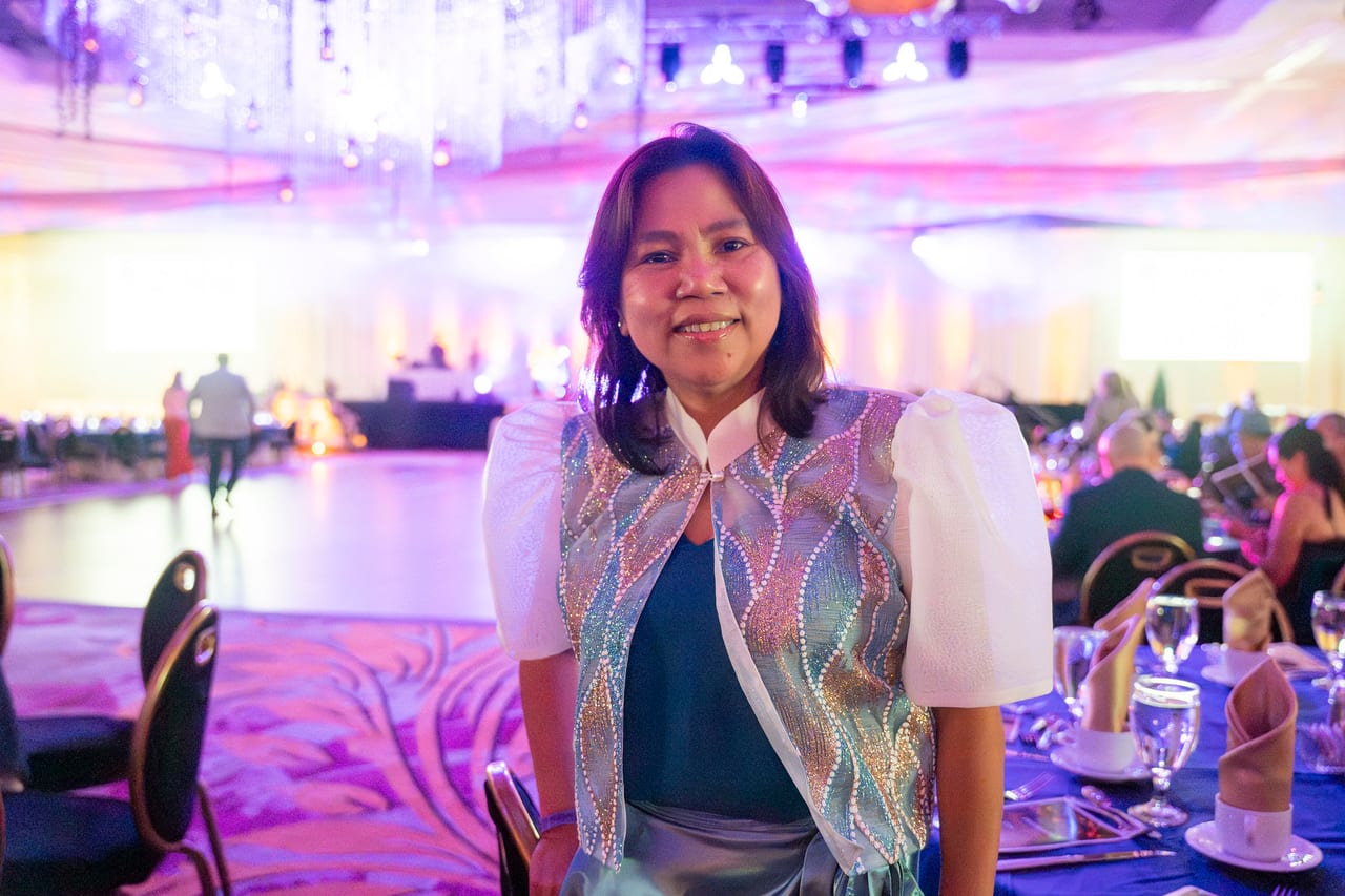 A Renown guest in an embroidered jacket smiling by the dance floor