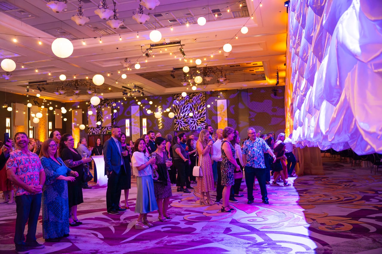 Renown guests filling the ballroom entrance under string lights and paper lanterns